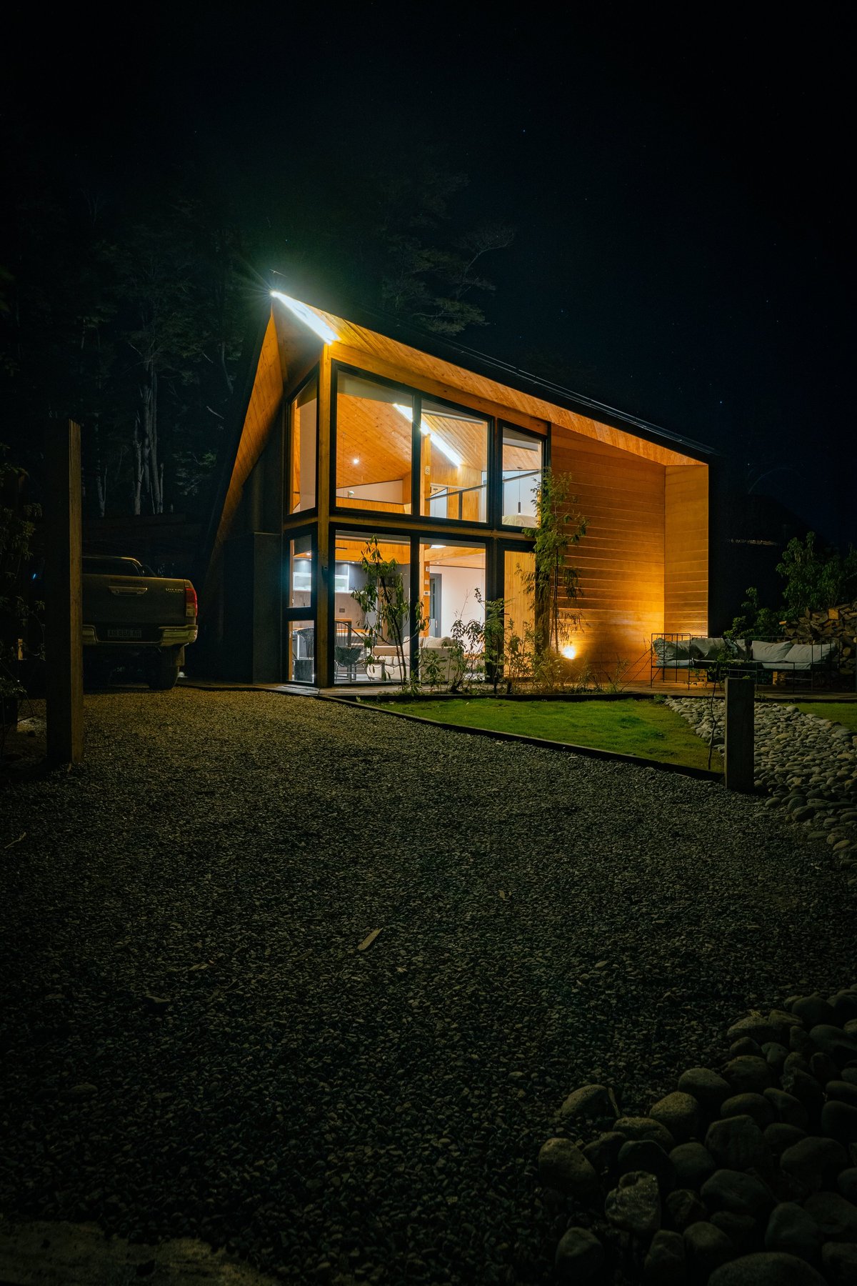 Modern wooden home warmly illuminated at night